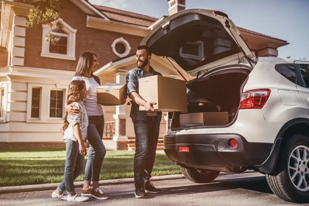 Family preparing for a household move beside their vehicle